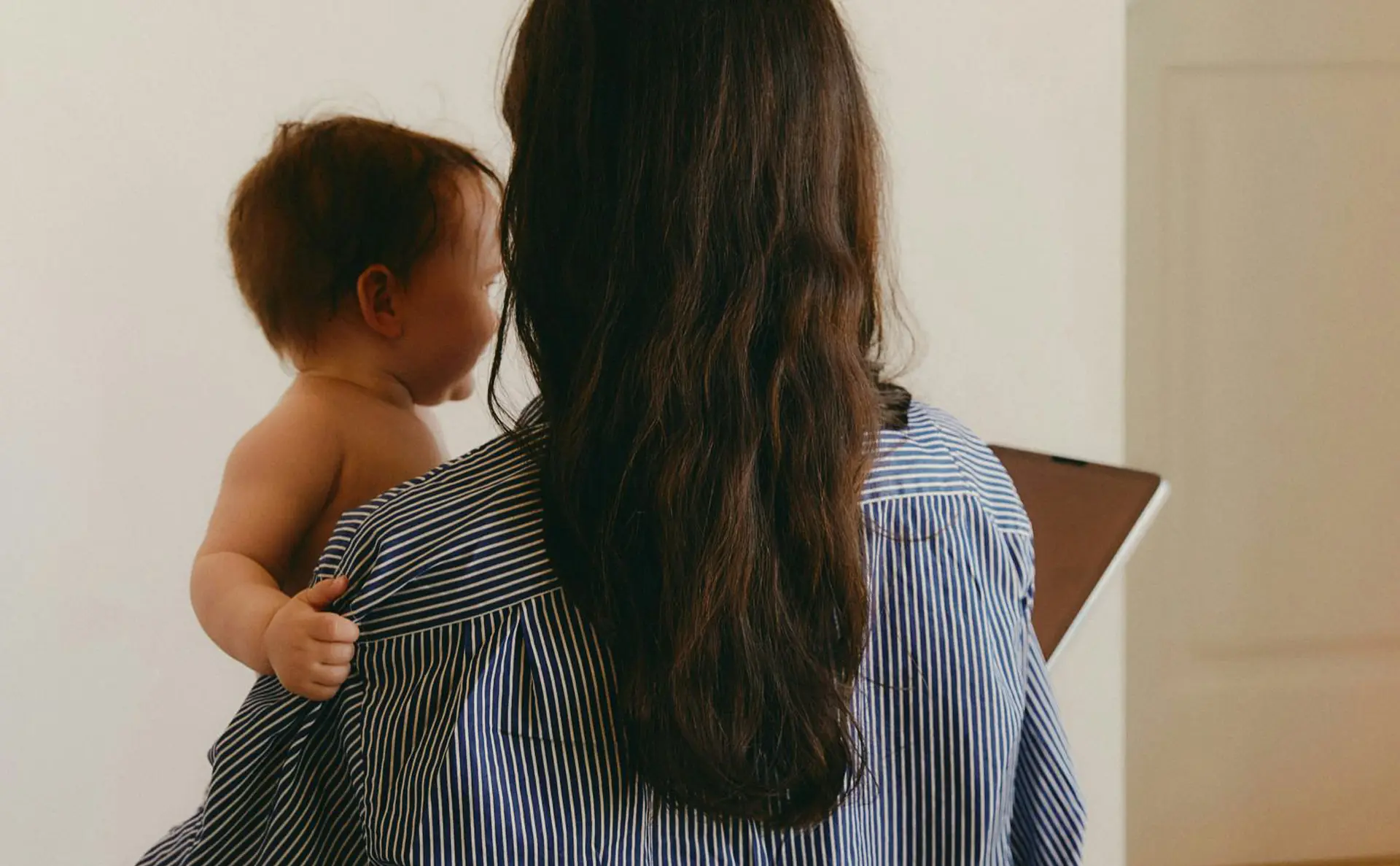 Woman holding baby and an iPad