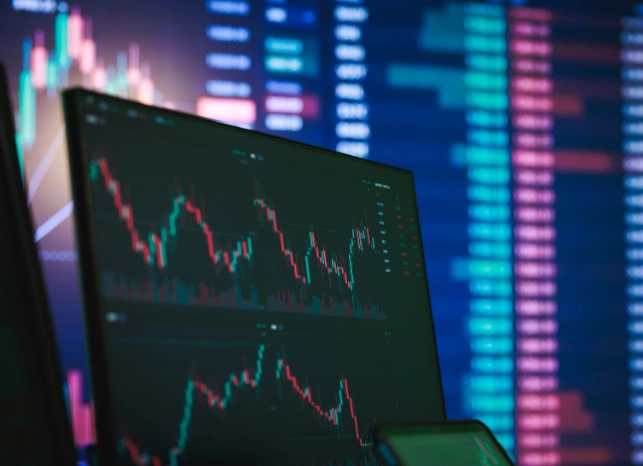 Stock chart visible on laptop screen.