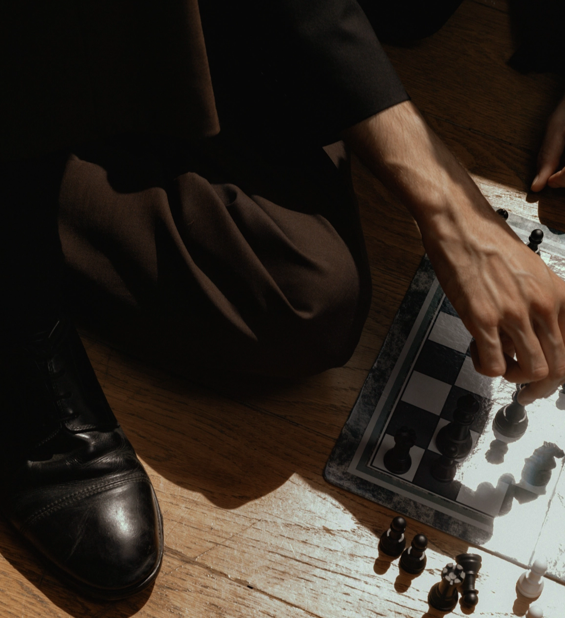 Mann sitzt am Boden und spielt Schach.